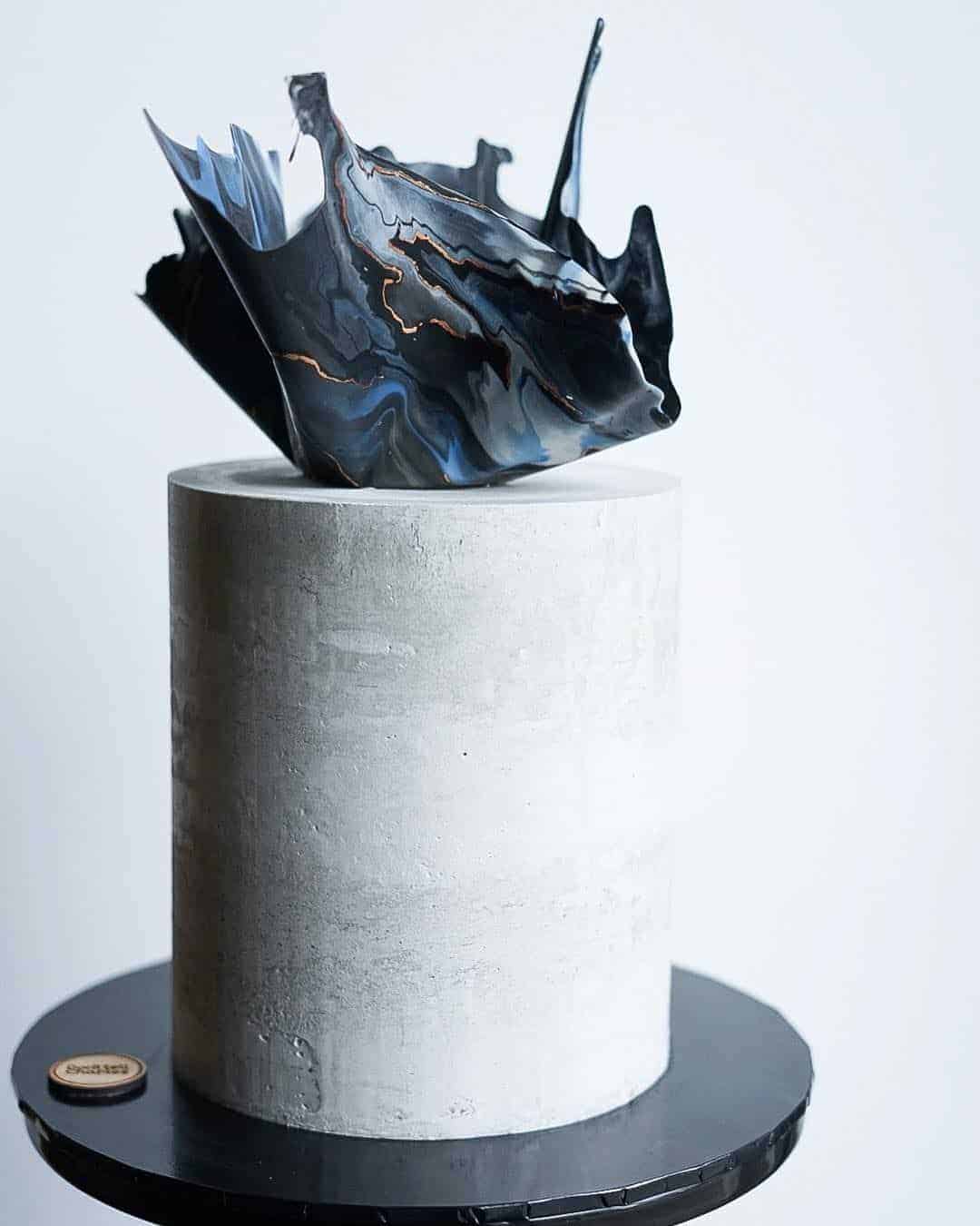 wedding cake with concrete texture and blue cake topper