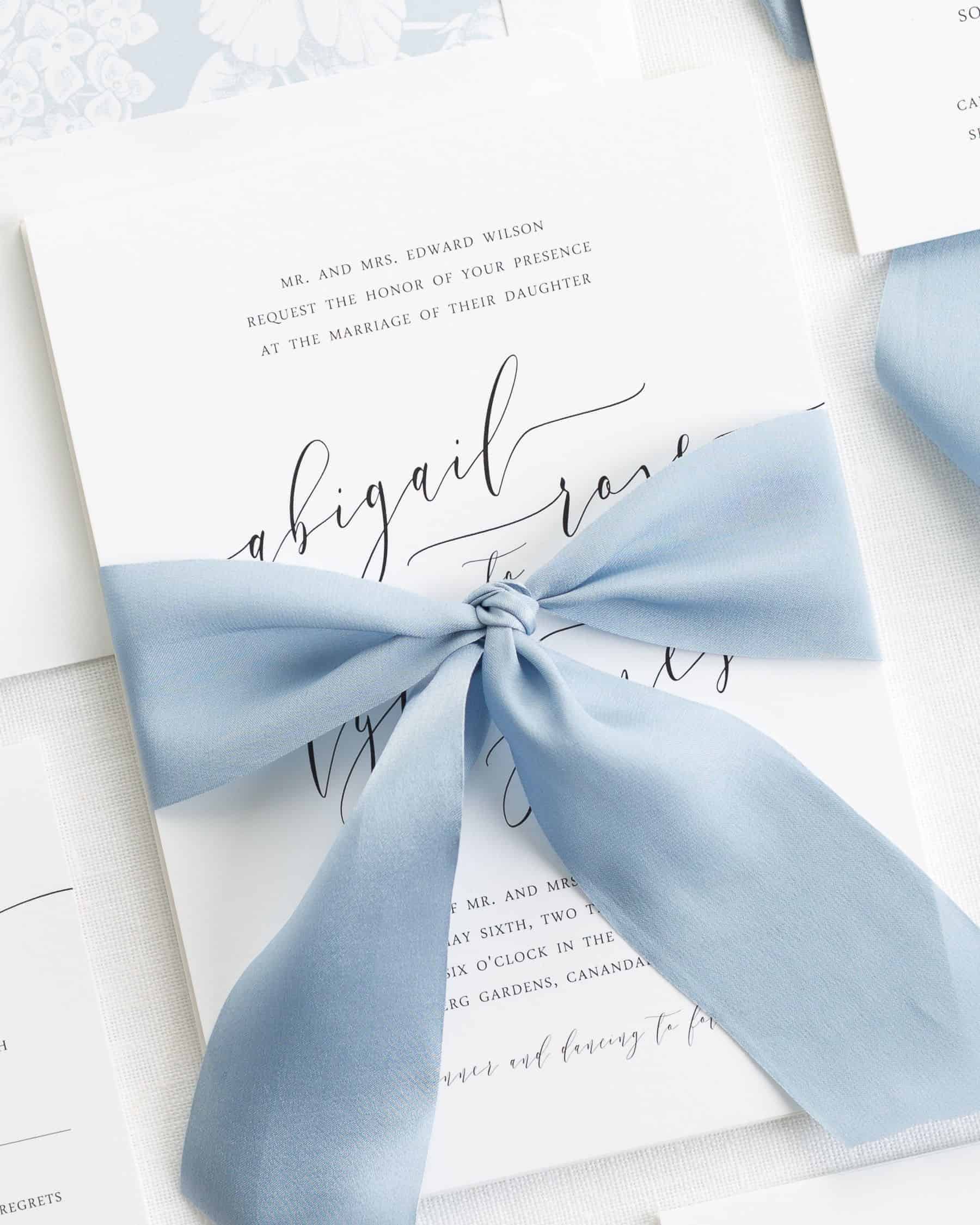 wedding invitation with a dusty blue ribbon