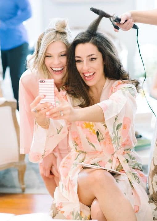 The bride prepared before the wedding and have a selfie photograph with her friend