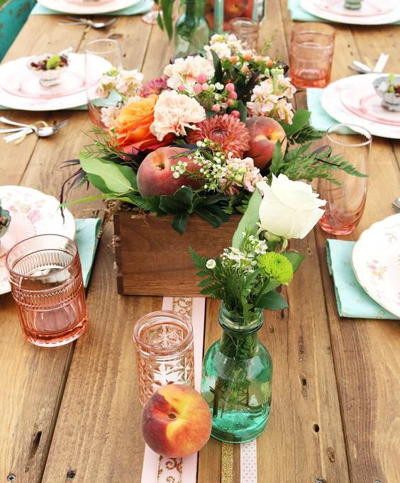 wedding decoration centrepiece with a wooden box with flowers and dark peaches