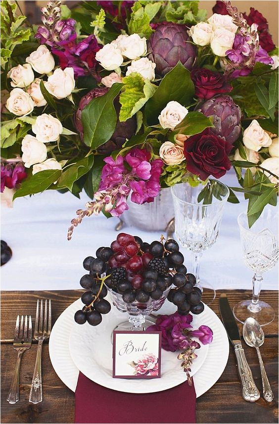 wedding decoration centrepiece with overflowing with flowers and cocktail made of forest fruit on the plate