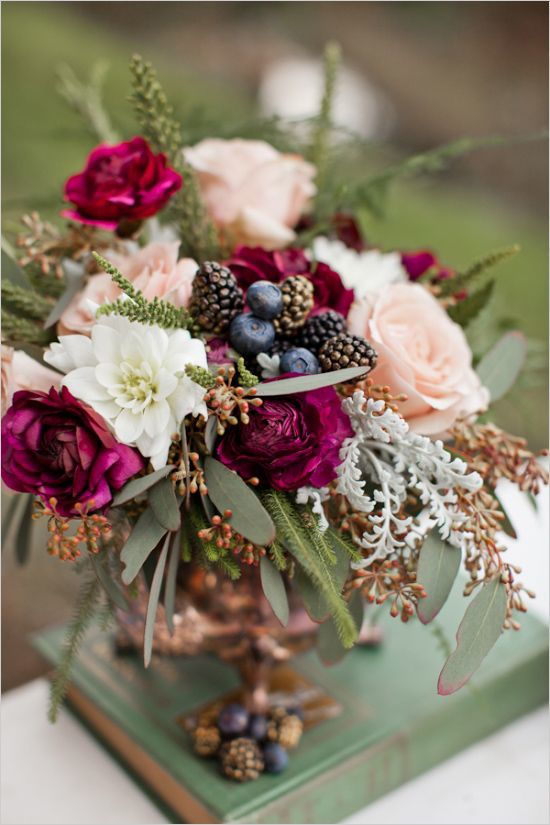 wedding decoration centrepiece with blueberries and blackberries and roses in shades of purple, fuchsia, white and soft pink